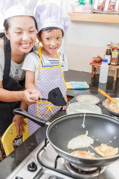 Little asian girl making pancake