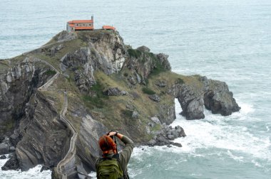 San Juan de Gaztelugatxe inziva yerinin fotoğraflarını çeken kadın fotoğrafçı..
