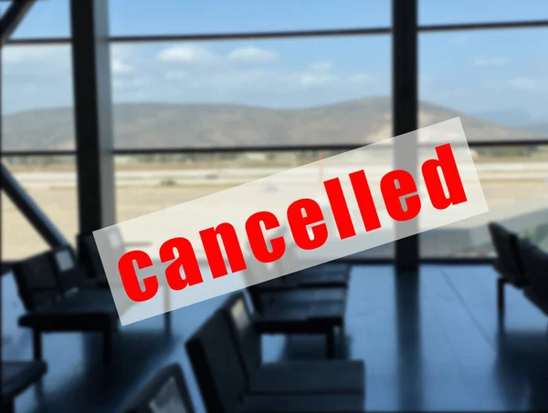 A warning sign that the flight is canceled on a defocused territory of the airport