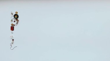 Düğmeler, kulak telleri, kilitler, pullar, beyaz arkaplandaki kolyeler gibi el yapımı aletlerden toplanan diy harflerinin görüntüsünü durdur.