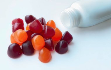 Kırmızı, turuncu ve mor multivitamin sakızları beyaz arka planda izole edilmiş. Sağlıklı yaşam tarzı kavramı.