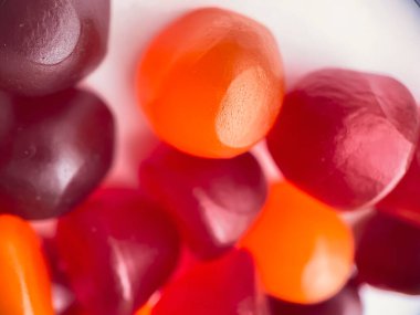 Kırmızı, turuncu ve mor multivitamin sakızlarının yakın çekim dokusu. Sağlıklı yaşam tarzı kavramı.