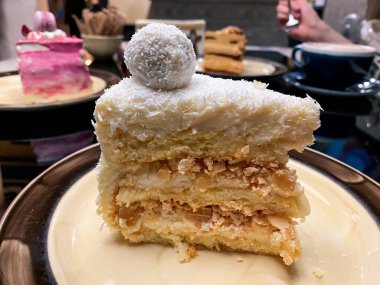 Pastanın üstüne sünger pastası, pembe krema ve pasta şeklinde süsleme ve restoranda bir tabakta kurumuş gül..