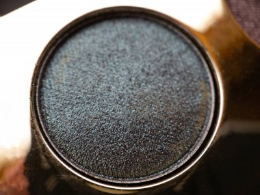 Göz makyajı yapmak için parlak gri bir göz farı yakın plan. Güzellik konsepti.