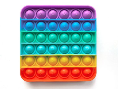 Çocuklar için gökkuşağı anti-stresli parmak itme oyuncağı beyaz arka planda izole edilmiş.. 