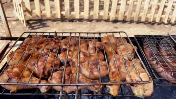 На гриле на территории частного дома во дворе готовятся куриные и свиные колбасы — стоковое видео