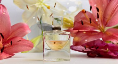 Beyaz arka planda çiçekli parfum. Pembe ve beyaz yapraklarla kaplı bir parfüm şişesi..
