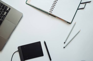 Çizimciler, tasarımcılar, dizüstü bilgisayarı olan sanatçılar, stili olan bir grafik tableti ve kalemli bir not defteri için düzenleme