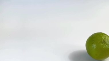 Beyaz arka plandaki masada yavaş çekim kireç rulosu.