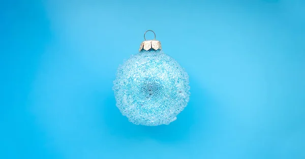 Palla di Natale blu con alcuni urti su uno sfondo blu. Design natalizio minimale, posto per testo — Foto Stock