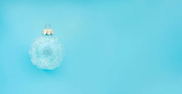 Μπλε χριστουγεννιάτικη μπάλα με μερικά εξογκώματα σε μπλε φόντο. Ελάχιστος χριστουγεννιάτικος σχεδιασμός, τόπος για κείμενο — Φωτογραφία Αρχείου