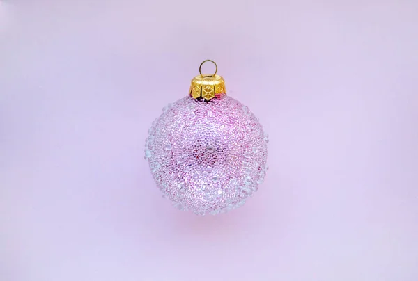 Bola de Navidad rosa con algunos bultos sobre un fondo rosa. Diseño mínimo de Navidad, lugar para el texto —  Fotos de Stock