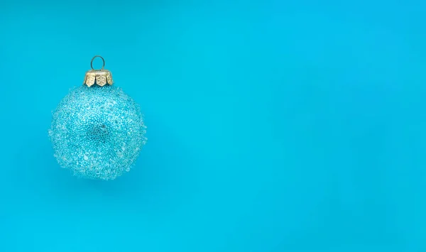 Palla di Natale blu con alcuni urti su uno sfondo blu. Design natalizio minimale, posto per testo — Foto Stock