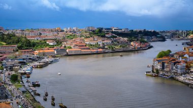 Portekiz 'in Porto ve Vila Nova de Gaia kentlerinden geçen Douro Nehri' nin geniş, panoramik ve yüksek açılı bir görüntüsü. Görüntü, binalarla tarihi ve renkli şehir manzarasını yakalıyor.
