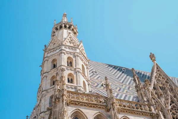 Avusturya, Viyana 'daki ünlü St. Stephens Katedrali Stephansdom' un mimari detayları. Bu alçak açılı çekim, karmaşık Gotik kuleleri ve eşsiz, renkli kiremitli çatısını yakalıyor.