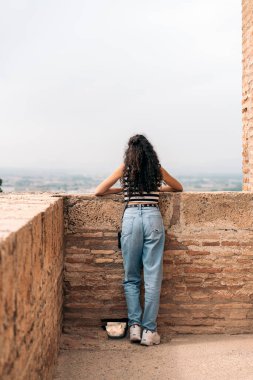 İspanya 'da Granada' nın siluetine bakan tanınmayan bir kadının resmi. Alhambra 'da ve Sacromonte mahallesine bakıyor..