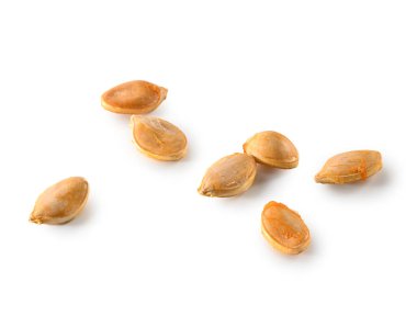 Beyaz arka planda posası olan birkaç taze kabak çekirdeği. 