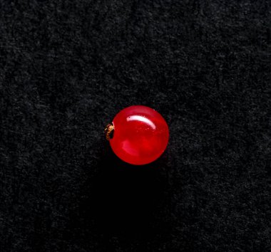 Şeffaf kırmızı frenk üzümü ve koyu dokulu arka planda ışık parlaması.