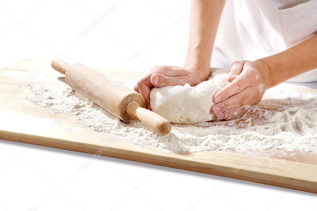 Hands kneading dough on  board