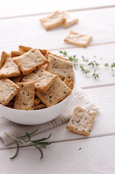 Crackers with herbs and black sesame seeds on table — Stock Photo, Image
