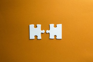 Bir yapbozun iki parçası birbirine uymaz. Turuncu arka planda beyaz parçalar. iş ve sosyal hayattan kaynaklanan sorunların kavramsal fotoğrafı