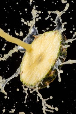 Ananas suyu serpilmiş bir dilim taze ananas. siyah arkaplan