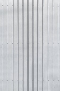 Çürük ve perçin kaplı metal bir yüzey, doğal ışıkla aydınlatılmış. Endüstriyel geçmiş. dikey konum.