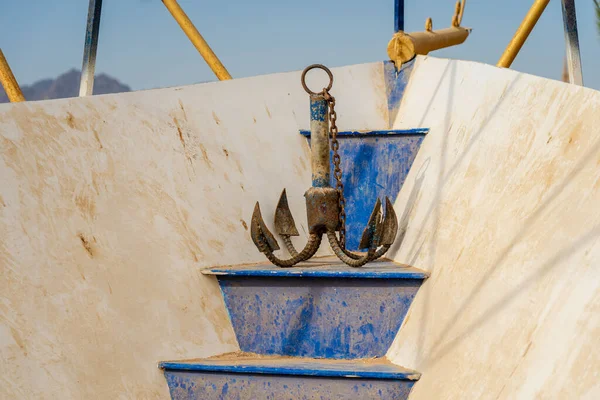 Old rusty four legged anchor on ship