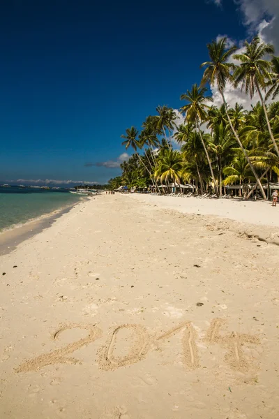 砂フィリピンで書かれた「2014」と静かなアロナビーチ — ストック写真
