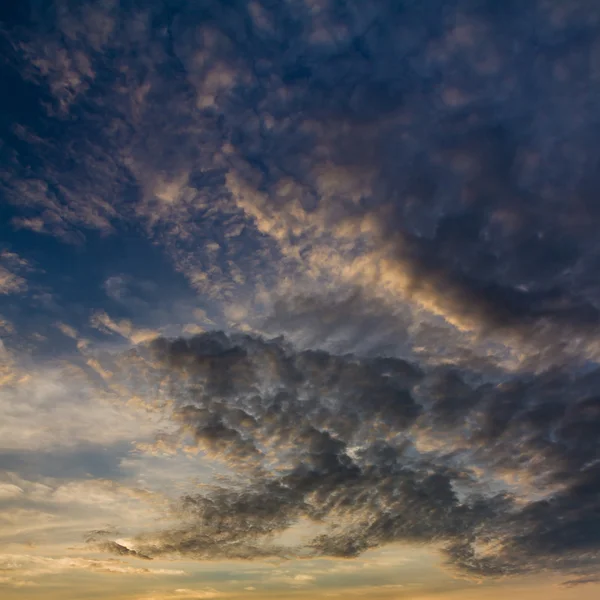 Nublado cielo azul oscuro durante la puesta del sol — Foto de Stock