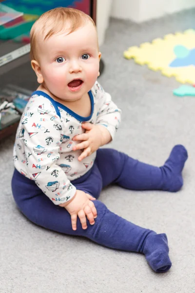 Adorable niñito sentado y sonriendo — Foto de Stock