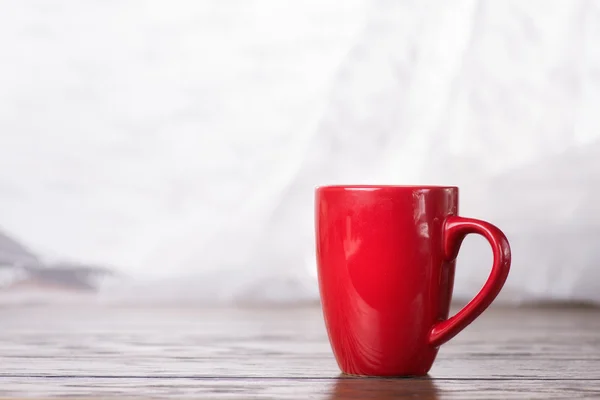 Taza roja en la mesa — Foto de Stock