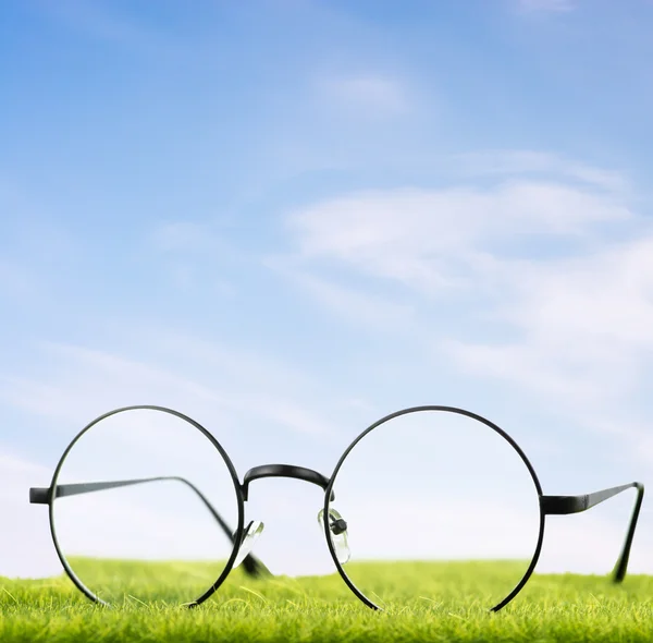 Brýle na trávě s oblohou — Stock fotografie