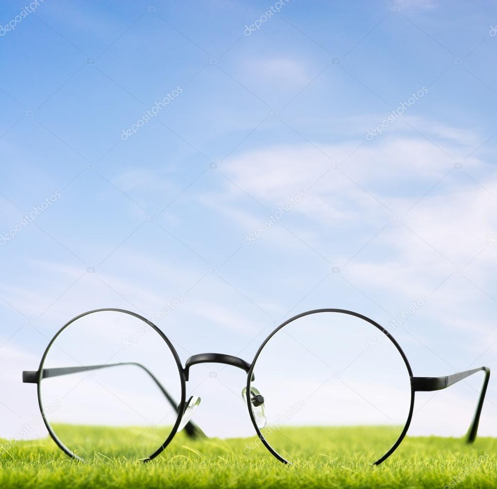 Eyeglasses on grass with sky