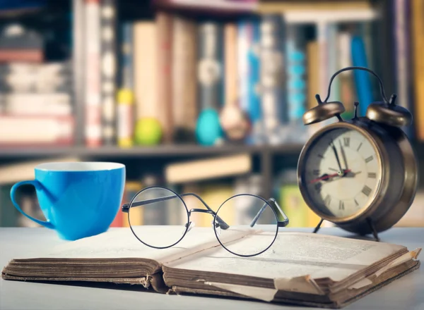 Gammal bok, glasögon, klocka och cup — Stockfoto