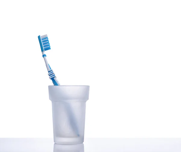 Toothbrush in glass on shelf — Stock Photo, Image