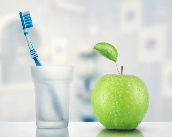 Зубная щетка и зеленое яблоко — стоковое фото