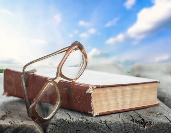 Óculos e livro na mesa — Fotografia de Stock