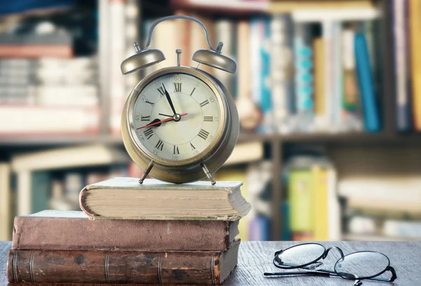 Stare książki, zegar i okulary — Zdjęcie stockowe