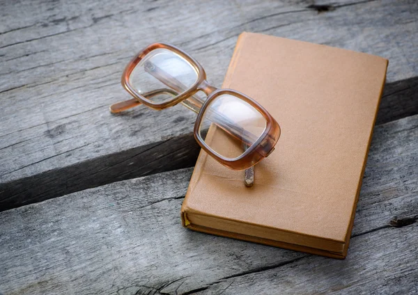 나무 탁자 위에 놓인 안경과 책 — 스톡 사진