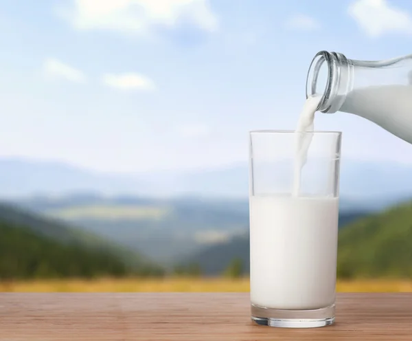 Verter leche en un vaso — Foto de Stock