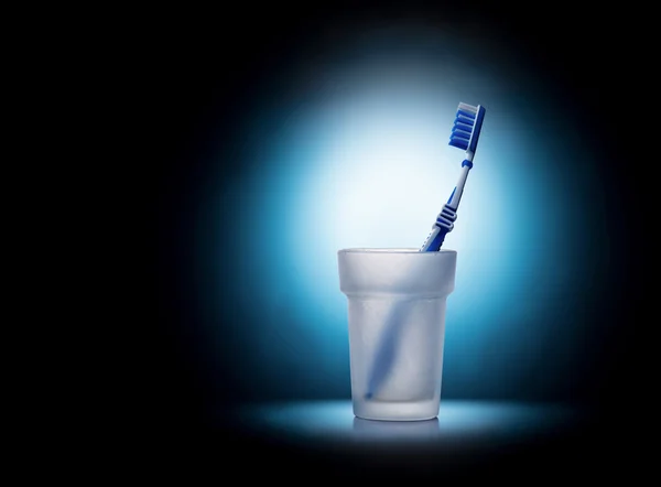 Toothbrush in glass on blue background — Stock Photo, Image