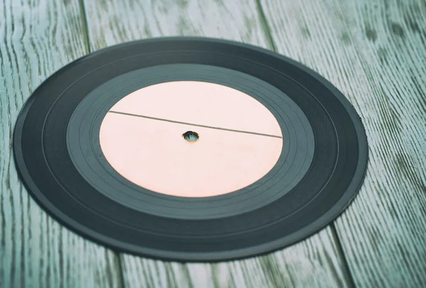 Disco de vinil em fundo de madeira — Fotografia de Stock