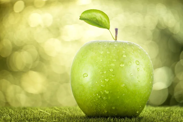 Green apple on grass — Stock Photo, Image