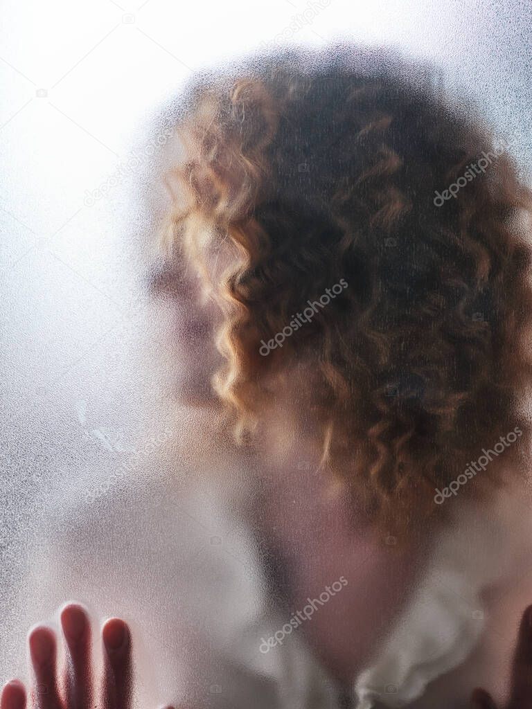 Silhouette of a girl behind frosted glass