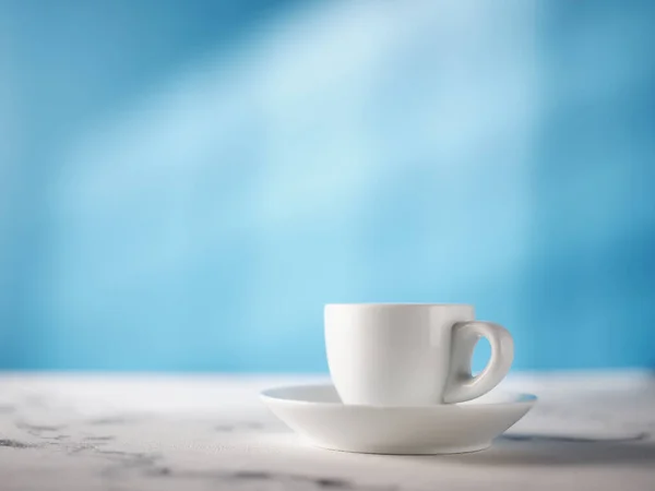 ブルーキッチンの背景にある白いエスプレッソカップ — ストック写真