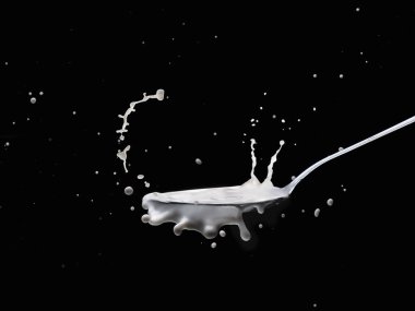 Siyah arkaplanda kaşık içinde süt sıçraması