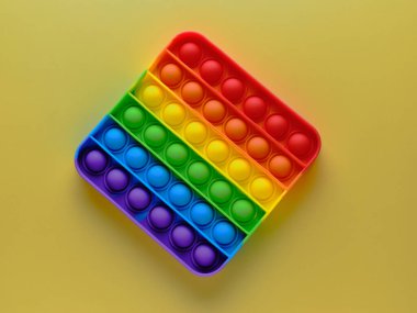 sarı arkaplanda gökkuşağı renkli popit oyuncağı