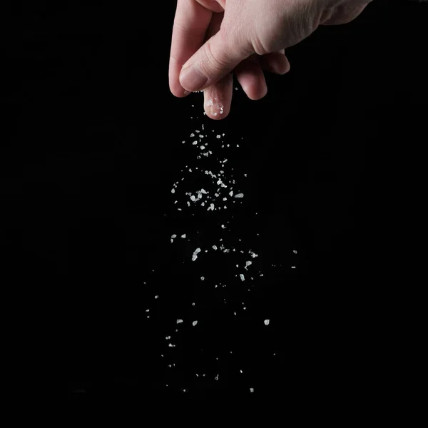 Ręka Kapiąca Sól Czarnym Tle — Zdjęcie stockowe