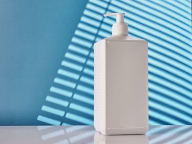 Mavi duvarda beyaz antiseptik konteynır